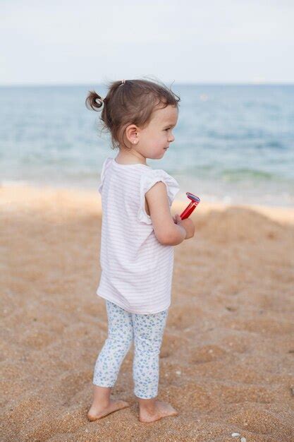 Doce garotinha na praia de verão de férias à beira-mar | Foto Premium