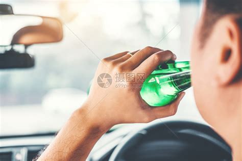 醉酒男子驾驶一辆汽车在路上载着啤酒瓶的车危险醉酒驾驶概念男注意力瓶子高清图片下载-正版图片307961428-摄图网