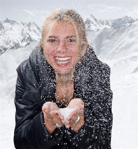 年轻的女人在雪地里捧着雪微笑高清图片下载-正版图片501521122-摄图网