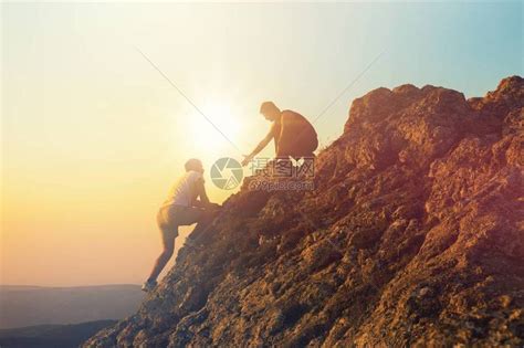 两个人在日落时爬上山高清图片下载-正版图片503538550-摄图网