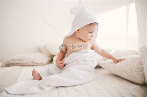 美丽微笑的新生男婴用白色竹毛巾盖着有趣的高清图片下载-正版图片505015280-摄图网