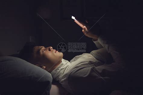躺在床上玩手机的男性高清图片下载-正版图片501080586-摄图网