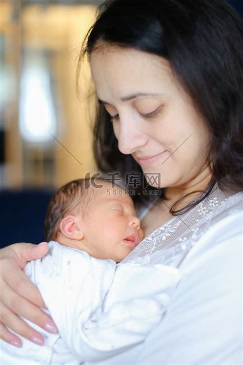 年轻的母亲抱着刚出生的婴儿。高清摄影大图-千库网