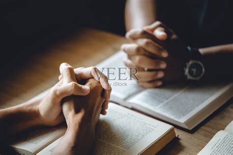 基督教团体的人们手牵着手祈祷，崇拜，相信和圣经在一个木桌上的虔诚或祈祷会议的概念。“n照片摄影图片_ID:412944956-Veer图库