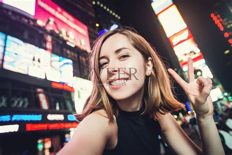 纽约时代广场，一名女游客在自拍照片摄影图片_ID:154415143-Veer图库