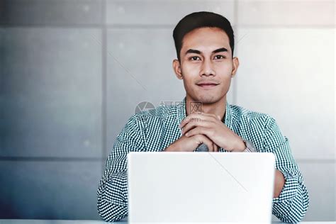 聪明的亚洲青年商业家在办公室微笑和看相机电脑笔记本上工作英俊的在职打算高清图片下载-正版图片307825409-摄图网