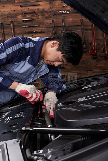 专心的汽车修理工男独自工作着修理车底，查看细节，排除汽车故障。照片摄影图片_ID:393875836-Veer图库