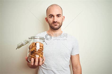 年轻人拿着一罐巧克力饼干高清图片下载-正版图片503872917-摄图网