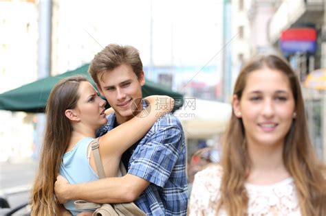 不忠的男人拥抱他女朋友却在街上寻找另一个女朋友高清图片下载-正版图片304146839-摄图网