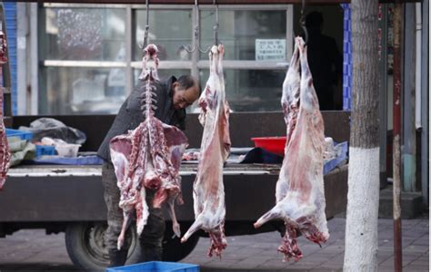 西安回民街人们习惯于挂着羊肉边切边烤，其乐融融