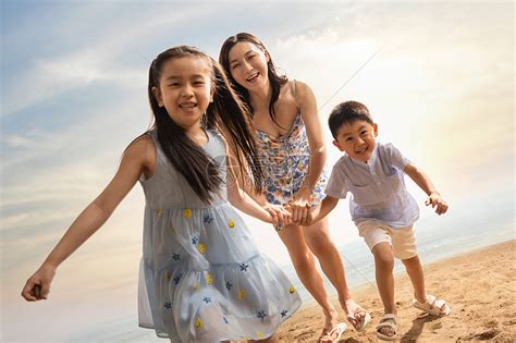 年轻母亲牵着两个孩子在沙滩上奔跑高清图片下载-正版图片507635201-摄图网
