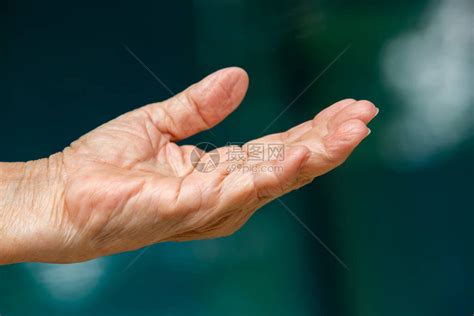 高龄女左手在她手上展示了什么东西在bokeh蓝色游泳池背景亚洲皮肤部分符号诱导身高清图片下载-正版图片504002194-摄图网