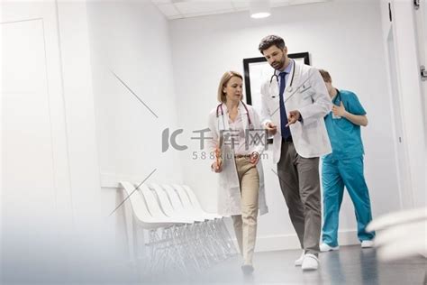 护士走在医生后面在医院走廊讨论情侣装吊带睡衣高清摄影大图-千库网