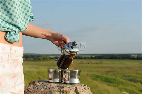 女孩把咖啡倒在两个杯子里高清图片下载-正版图片507403612-摄图网