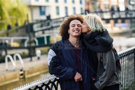 快乐的夫妇伦敦小威尼斯的卡姆登镇玩得很开心英国年轻女子亲吻男友的脸快乐的情侣卡姆登镇小威尼斯玩得开心,高清图片下载-正版图片300018357-摄图网