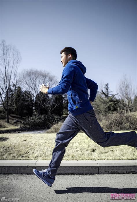 年轻英俊的中国男子在体育场跑道上跑步锻炼前摆明星姿势。挑战运动员在起点奔跑的比赛照片摄影图片_ID:420809285-Veer图库