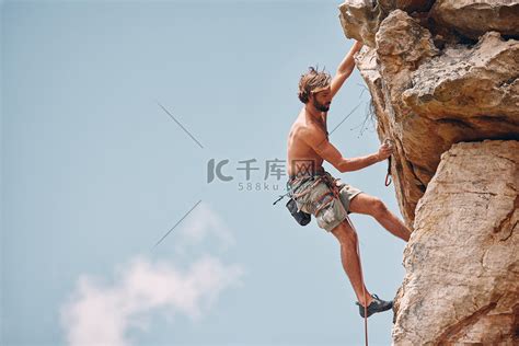 男子登山或攀岩，而悬崖悬挂和肾上腺素运动员冒险并检查安全设备、钩子和绳索。高清摄影大图-千库网