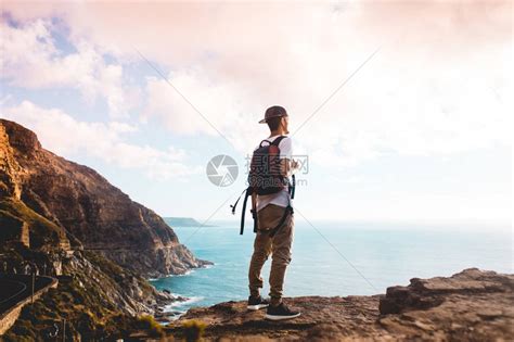站在悬崖边上的年轻徒步旅行者高清图片下载-正版图片503596664-摄图网