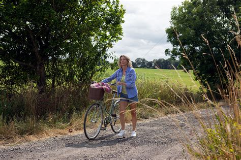 在农村公路沿途推自行车的孕妇高清图片下载-正版图片501888791-摄图网