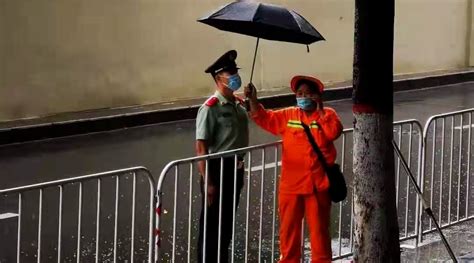 环卫工人雨中为执勤武警撑伞：撑了20分钟，最后把伞给他了_新浪新闻