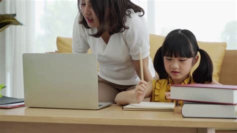 亚洲妈妈教孩子的女儿学习网上从家里，e -学习或自学家庭学校，倾斜向上的镜头视频素材_ID:VCG42N1278368633-VCG.COM