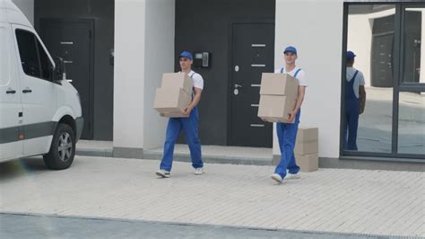 两个搬家公司的年轻工人正在把箱子和家具装上一辆小巴视频素材_ID:VCG42N1390330560-VCG.COM