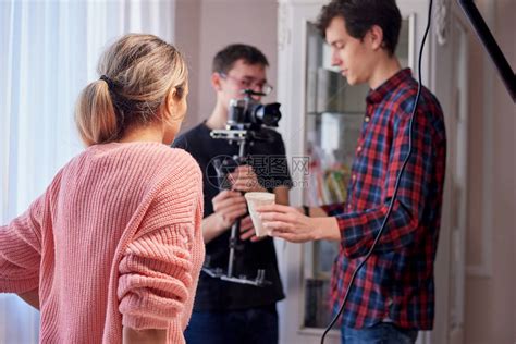 青年电影制片人与一名妇女一起在家里拍摄广告高清图片下载-正版图片506332386-摄图网