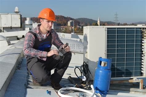 空调修理机修屋顶空调系统的年轻维修员高清图片下载-正版图片502887011-摄图网