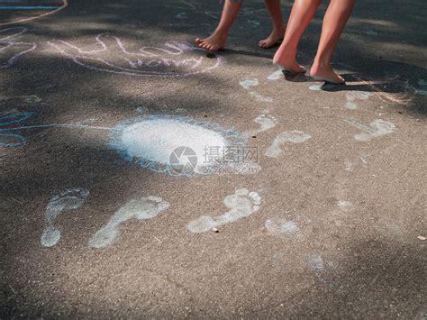 两姐妹光着脚在人行道上做粉笔脚印高清图片下载-正版图片501461818-摄图网