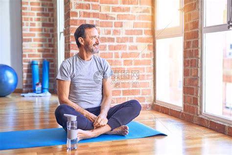 坐在床上的中年帅哥运动员在健身房做伸展瑜伽练习时高清图片下载-正版图片504502773-摄图网