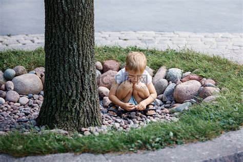 小男孩在公园里捡石头。高清摄影大图-千库网