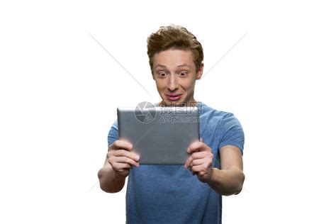 出乎意料的caucasian的家伙正在看他的平板电脑PC孤高清图片下载-正版图片504014988-摄图网