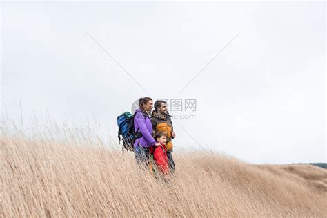 幸福家庭的侧面观背包站在高的干草地上仰望高清图片下载-正版图片502652344-摄图网