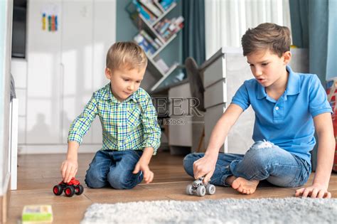 两个兄弟姐妹在室内玩模型车图片-商业图片-正版原创图片下载购买-VEER图片库