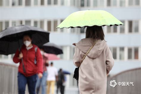 北京雨水飘落秋意浓 街头市民换厚装撑伞出行-图片频道