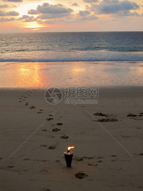 在浪漫的日落海滩上燃烧的火炬高清图片下载-正版图片505766758-摄图网