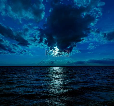 这张深蓝色月光下的海洋在夜间平静的波浪的照片插图将成为任何沿海地区或度假的绝佳旅行背景。高清摄影大图-千库网