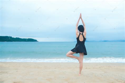 沙滩上进行瑜伽少女摄影图高清摄影大图-千库网