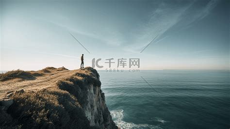 一个人站在悬崖边，旁边是一片水域高清摄影大图-千库网