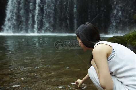 站在小溪边享受瀑布的女人在用杯子装溪水高清图片下载-正版图片502071688-摄图网