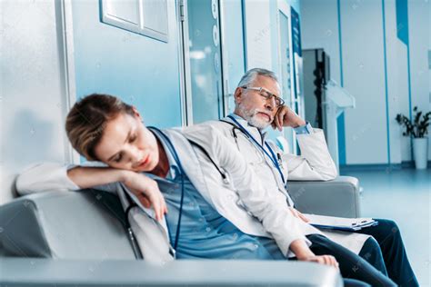 疲惫的男女医生睡在医院走廊的沙发上 高清摄影大图-千库网