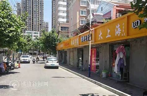 一男人在集市服装摊前挑选衣服高清图片下载_红动中国