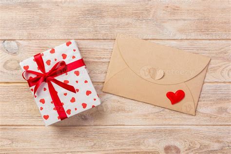 correo de sobre con corazón rojo y caja de regalo sobre fondo de madera ...