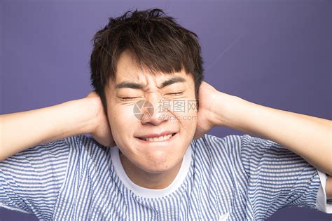 激动东方人紫色背景青年男人捂着耳朵高清图片下载-正版图片501972669-摄图网