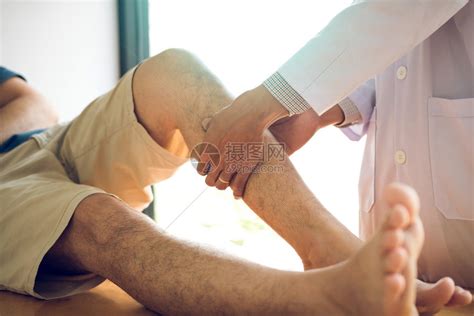 理疗师用手按病人小腿检查诊所疼痛和按摩情况高清图片下载-正版图片305636989-摄图网