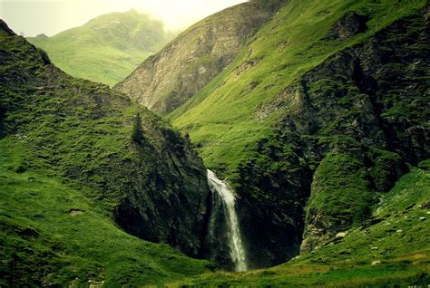 绵延起伏的高山之间有一条瀑布自然风景素材设计