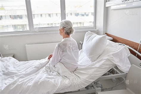 孤独的老妇人坐在医院的病床上