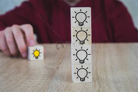 手工挑选了木板上标有黄灯泡符号的木制立方体新想法创新和高清图片下载-正版图片503988420-摄图网
