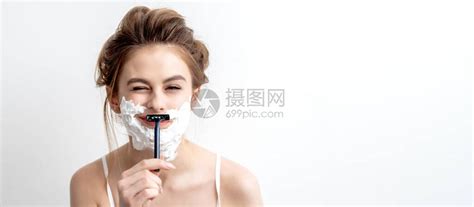 美丽的年轻caucasian女人用剃刀刮脸的白色背景高清图片下载-正版图片506639950-摄图网