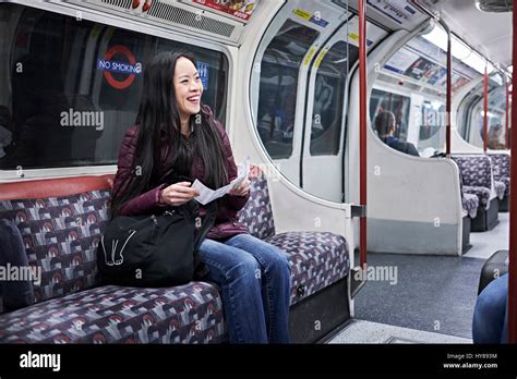 A young Japanese woman on a tube train in London Stock Photo - Alamy